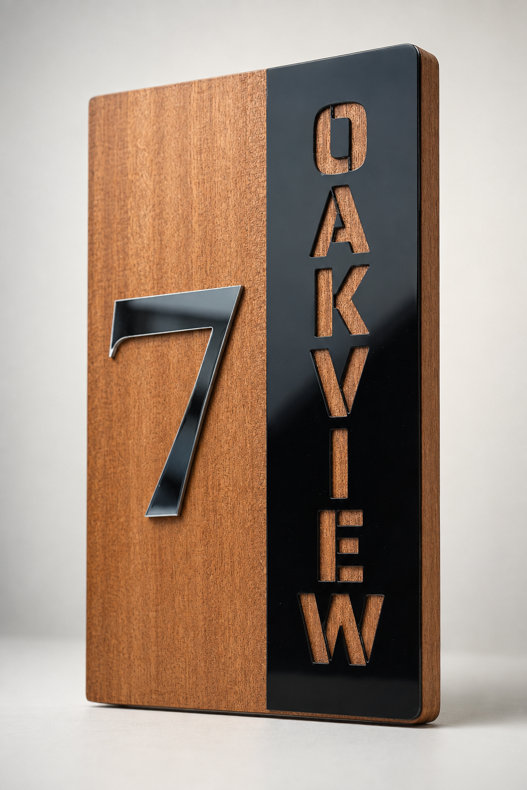 A modern rectangular wooden sign with a vertical black panel on the right featuring the carved word "OAKVIEW" and a large metallic silver number 7 on the left, shown on a light gray background.Lumora Craft Studio, lumorastudio.ie