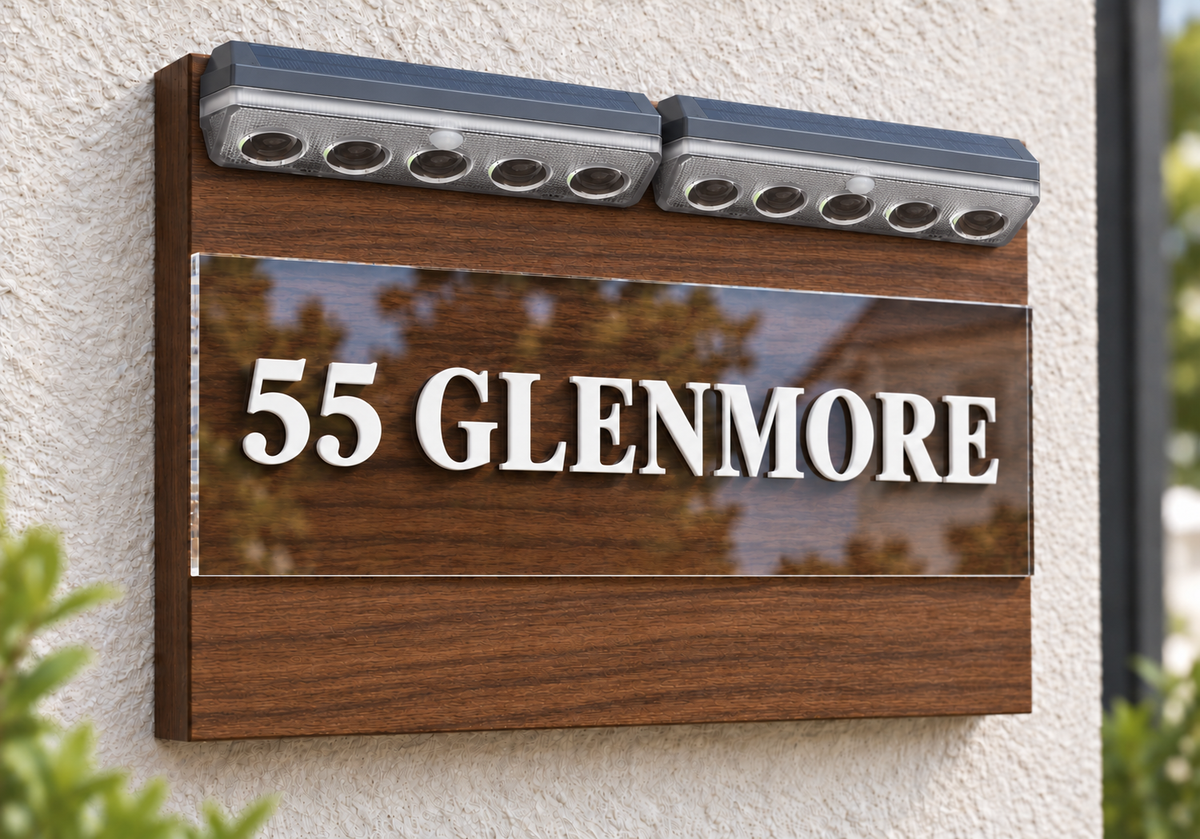 A modern wooden address plaque mounted on a textured stucco wall, featuring the text '55 GLENMORE' in raised white letters on a glossy dark panel, with two built-in LED light bars at the top.lumorastudio.ie lumora craft studio