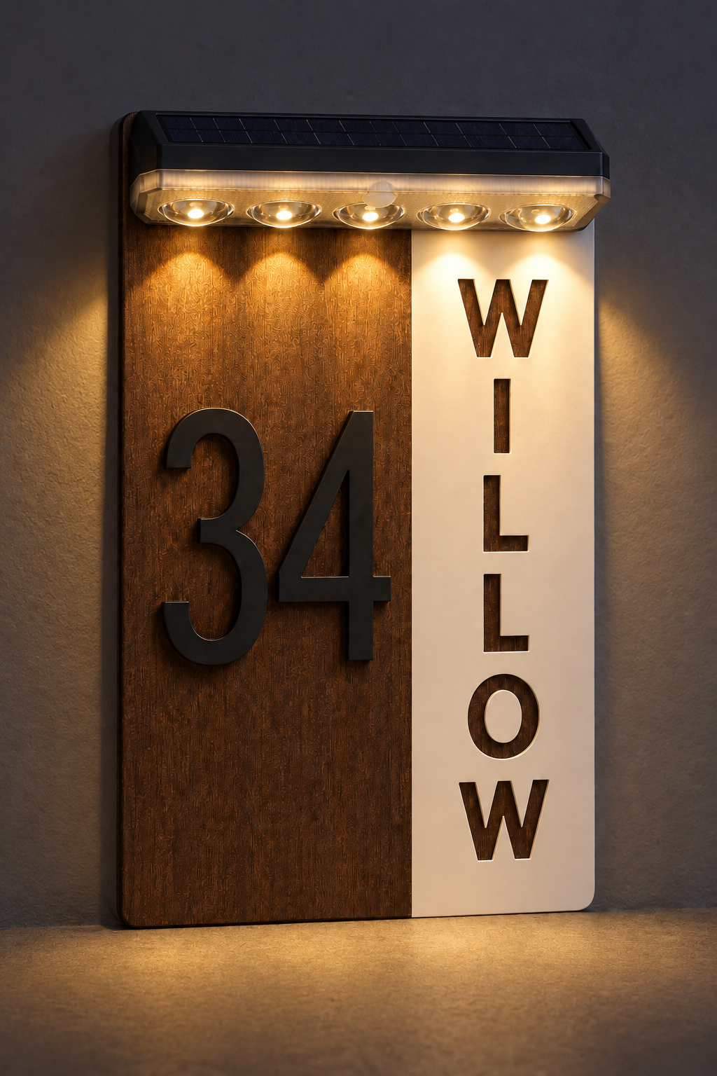 A vertical house number and name sign mounted on a wall, with a woodgrain panel showing the number 34 and a white panel showing the name WILLOW. The sign has a built-in solar panel at the top and illuminated LED lights above the numbers and name.Lumora Craft Studio, lumorastudio.ie
