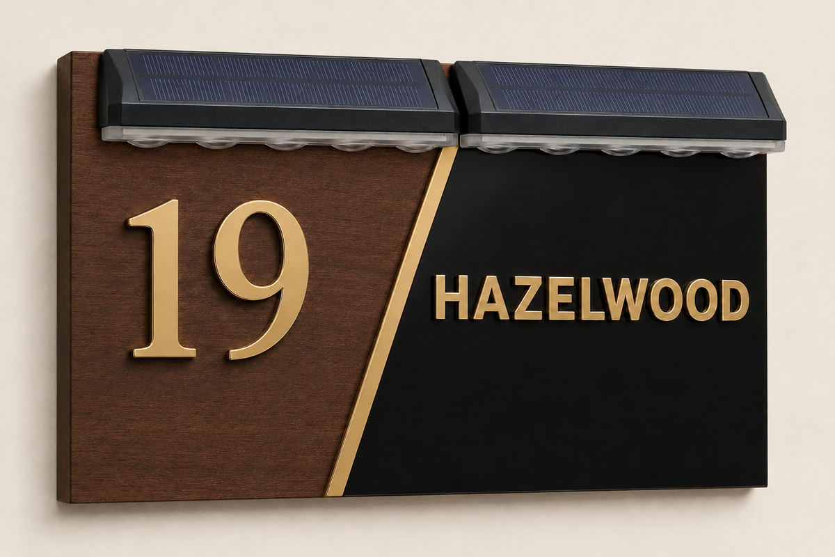 A modern house number and name sign mounted on a beige wall. The sign has a split design with a dark brown wood-grain left side featuring raised gold numerals '19', and a black right side with gold text reading 'HAZELWOOD'.lumorastudio.ie lumora craft studio