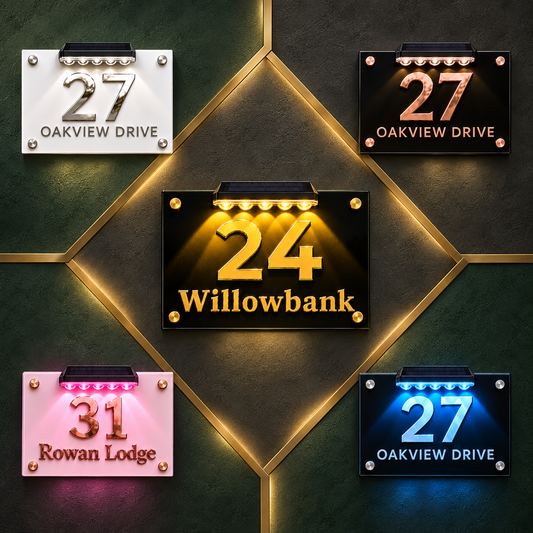 Five illuminated house number signs arranged on a dark green paneled background. The center sign reads '24 Willowbank' in glowing gold, while the surrounding signs show different color options: white, black, pink, and blue.lumorastudio.ie lumora craft studioPersonalised acrylic house plaque with raised acrylic lettering