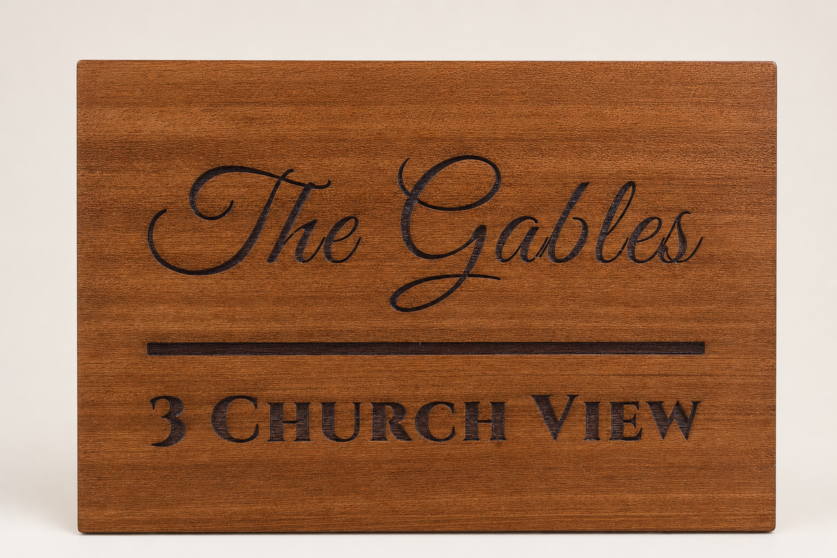 A rectangular wooden sign with engraved text reading 'The Gables' and '3 CHURCH VIEW' on a light neutral lumorastudio.ie lumora craft studiobackground.